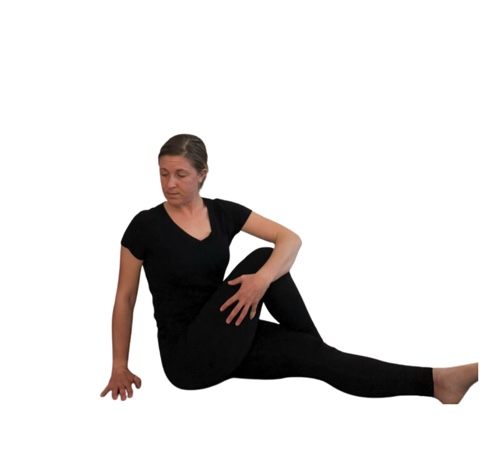 woman in black doing a seated back twist.