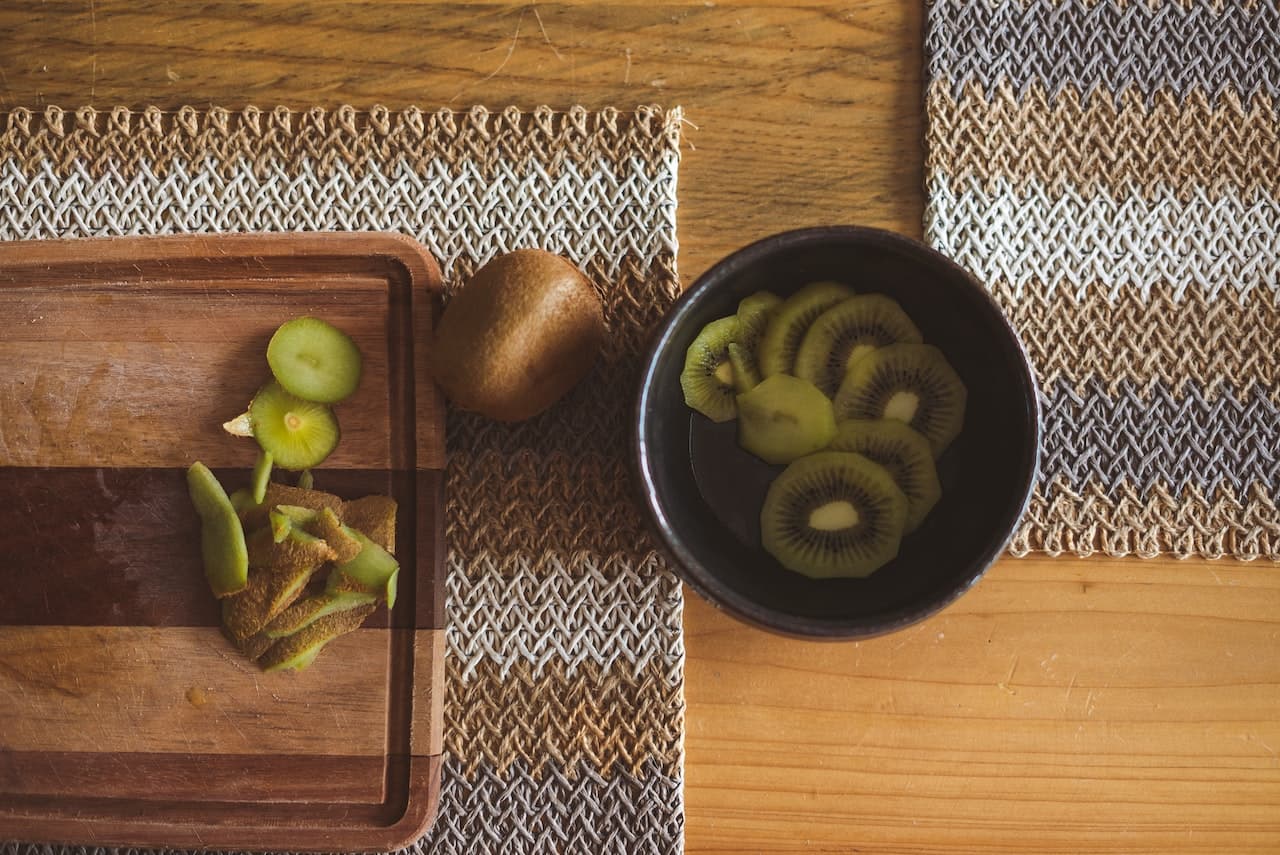 Slices-of-kiwi-in-a-bowl-on-wooden-table