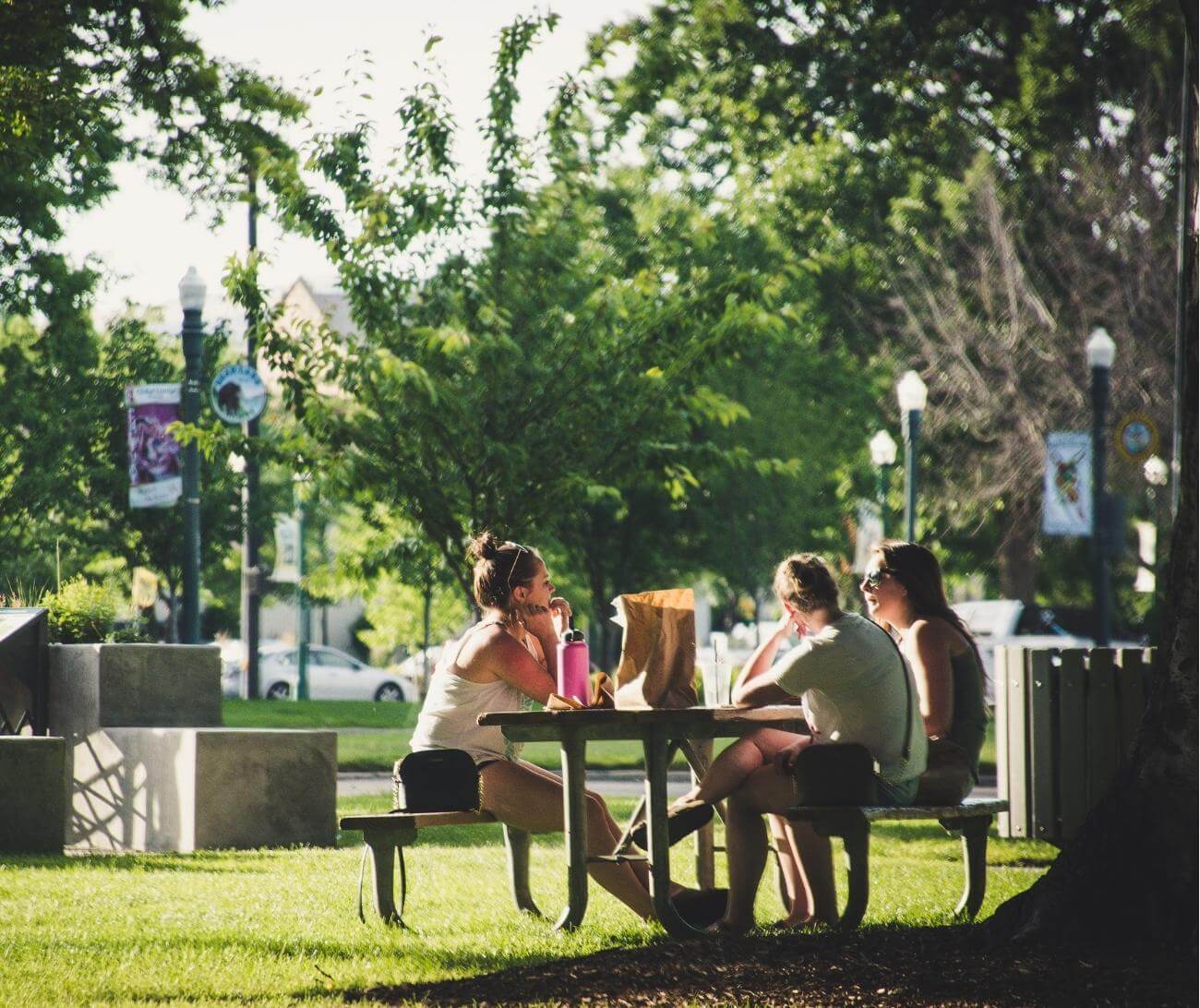 group of friends eating lunch in a park