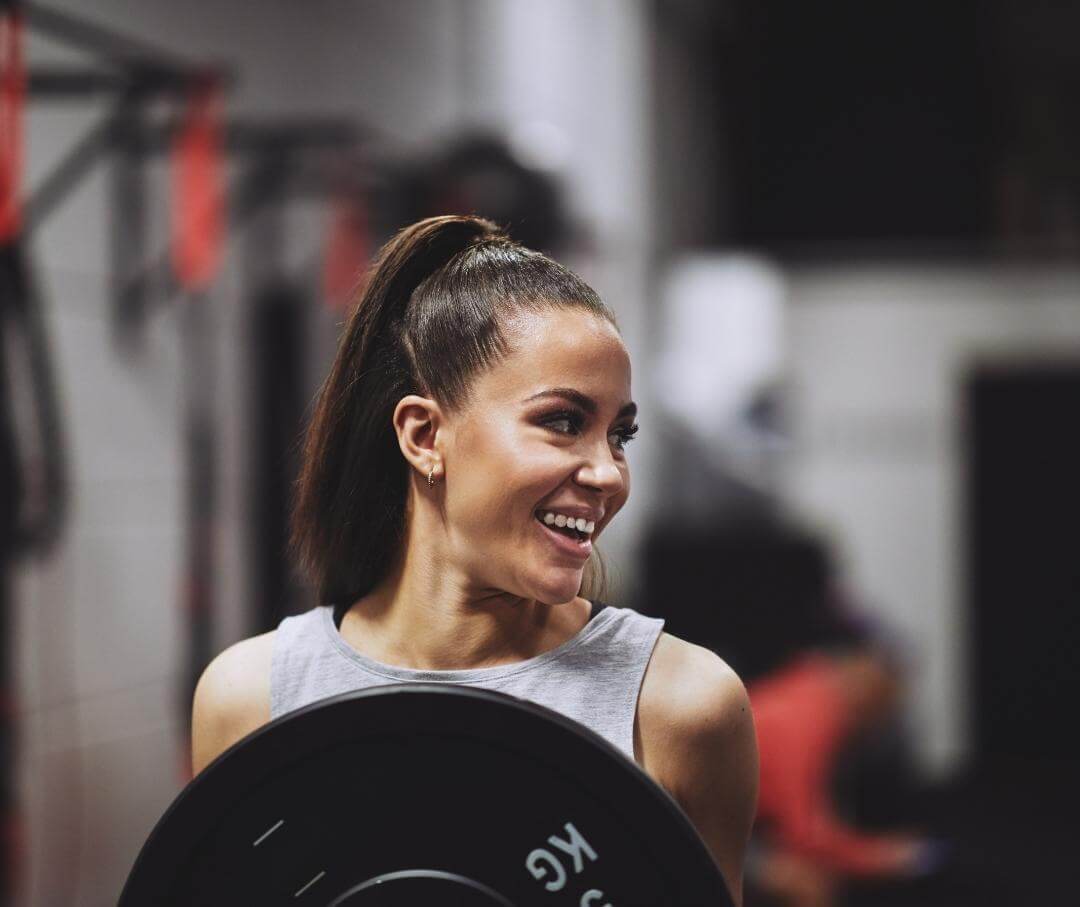 Woman at gym holding a 5 kg weight