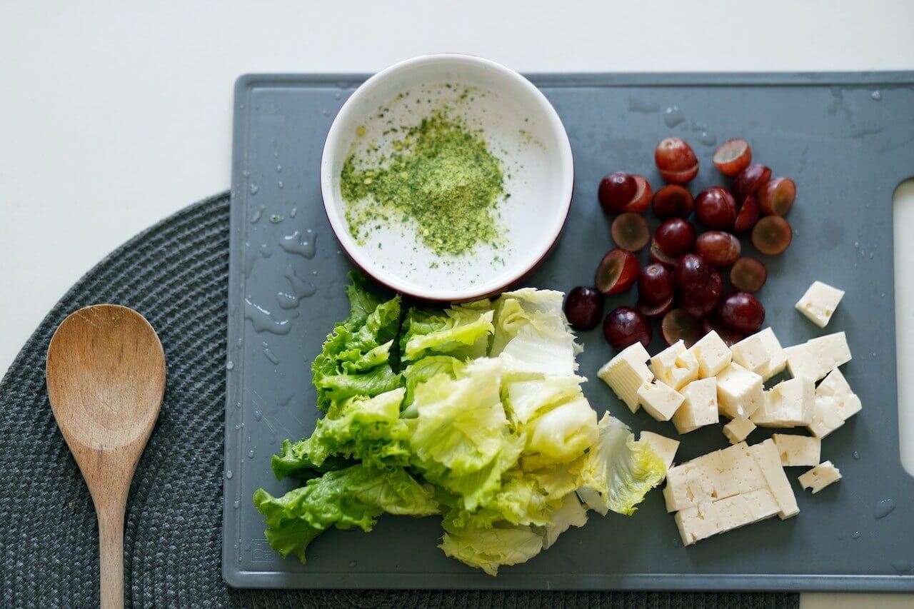 Slices-of-Tofu-Dates-and-Lettuce-on-Grey-Chopping-Board