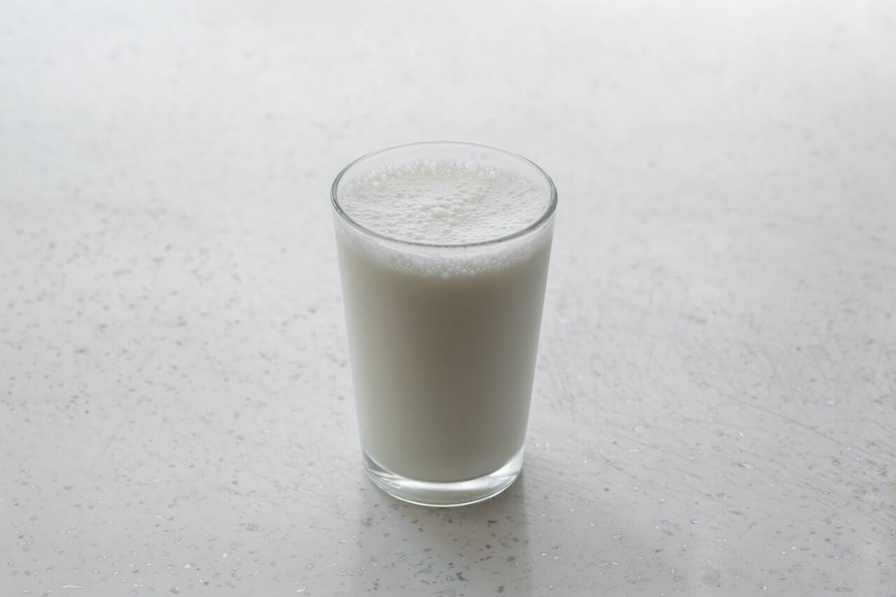 glass-of-milk-on-white-surface