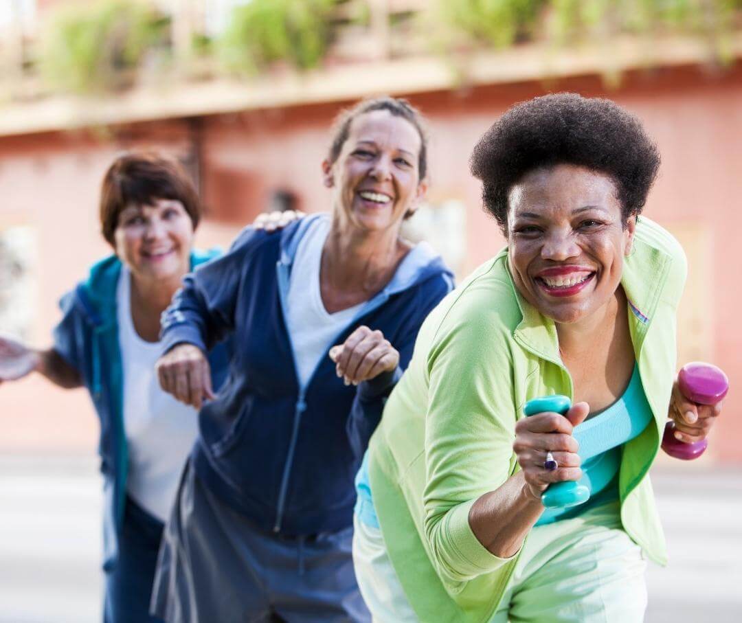 three women having fun exercising outdoors