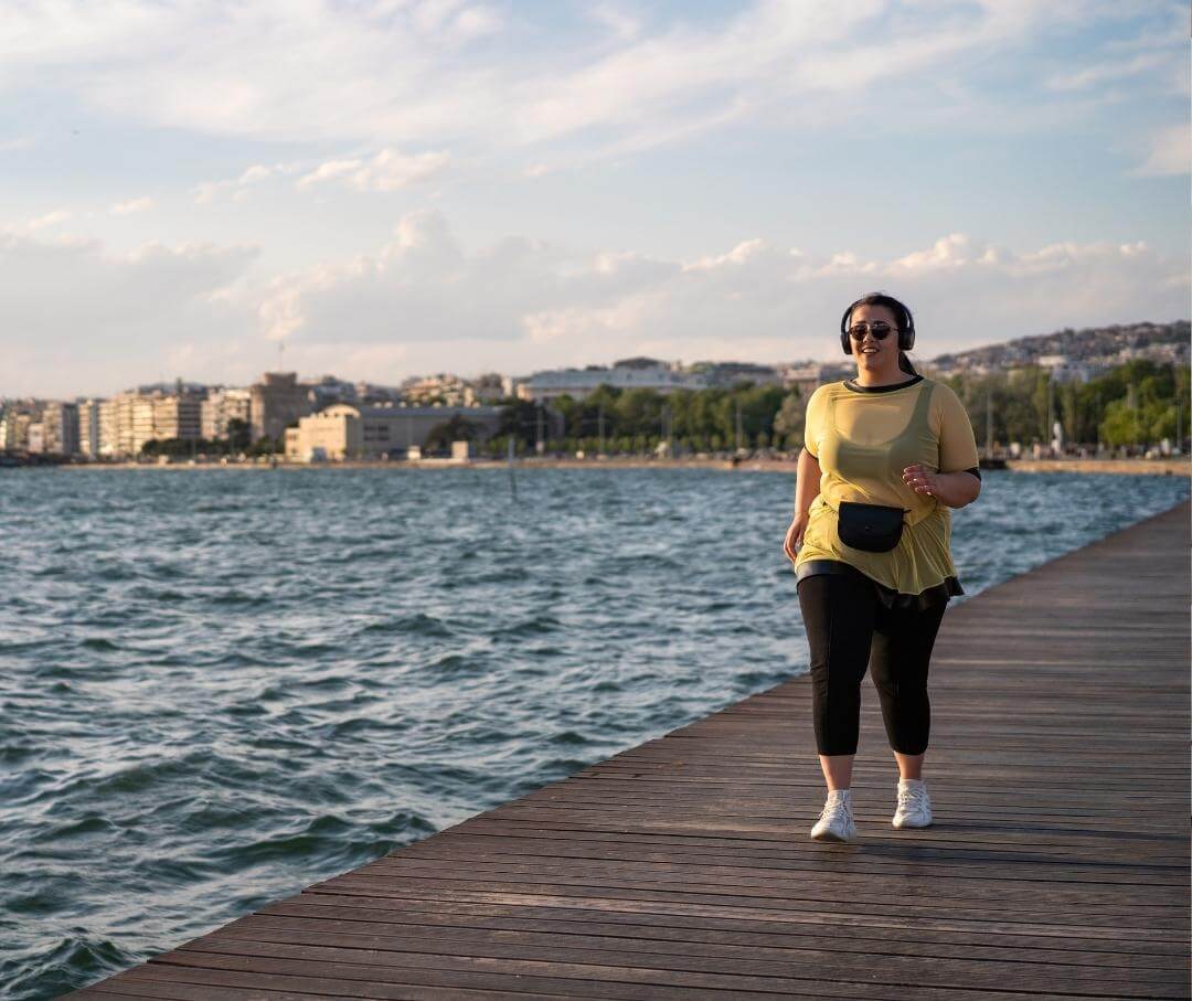 a heavyset woman walking on a pier