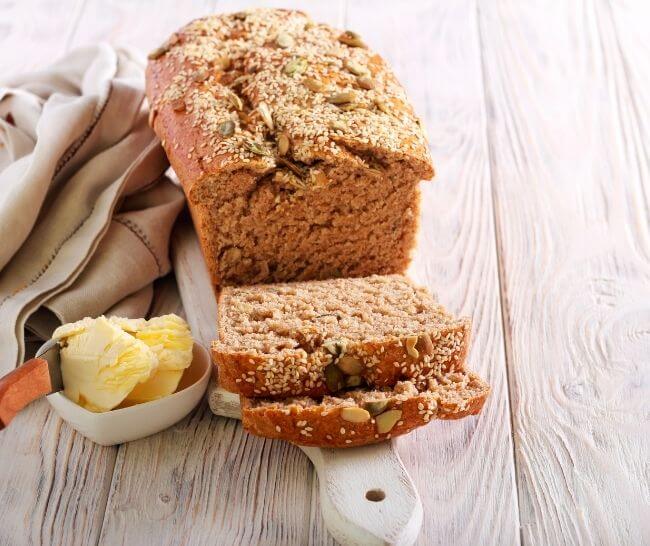 Whole wheat seeded bread, sliced on cutting board