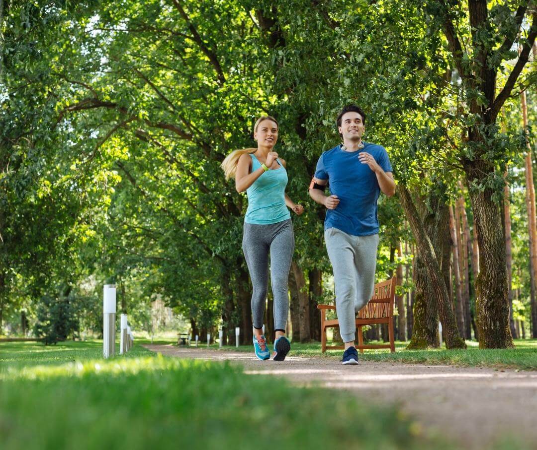 a woman and a man jogging in a park