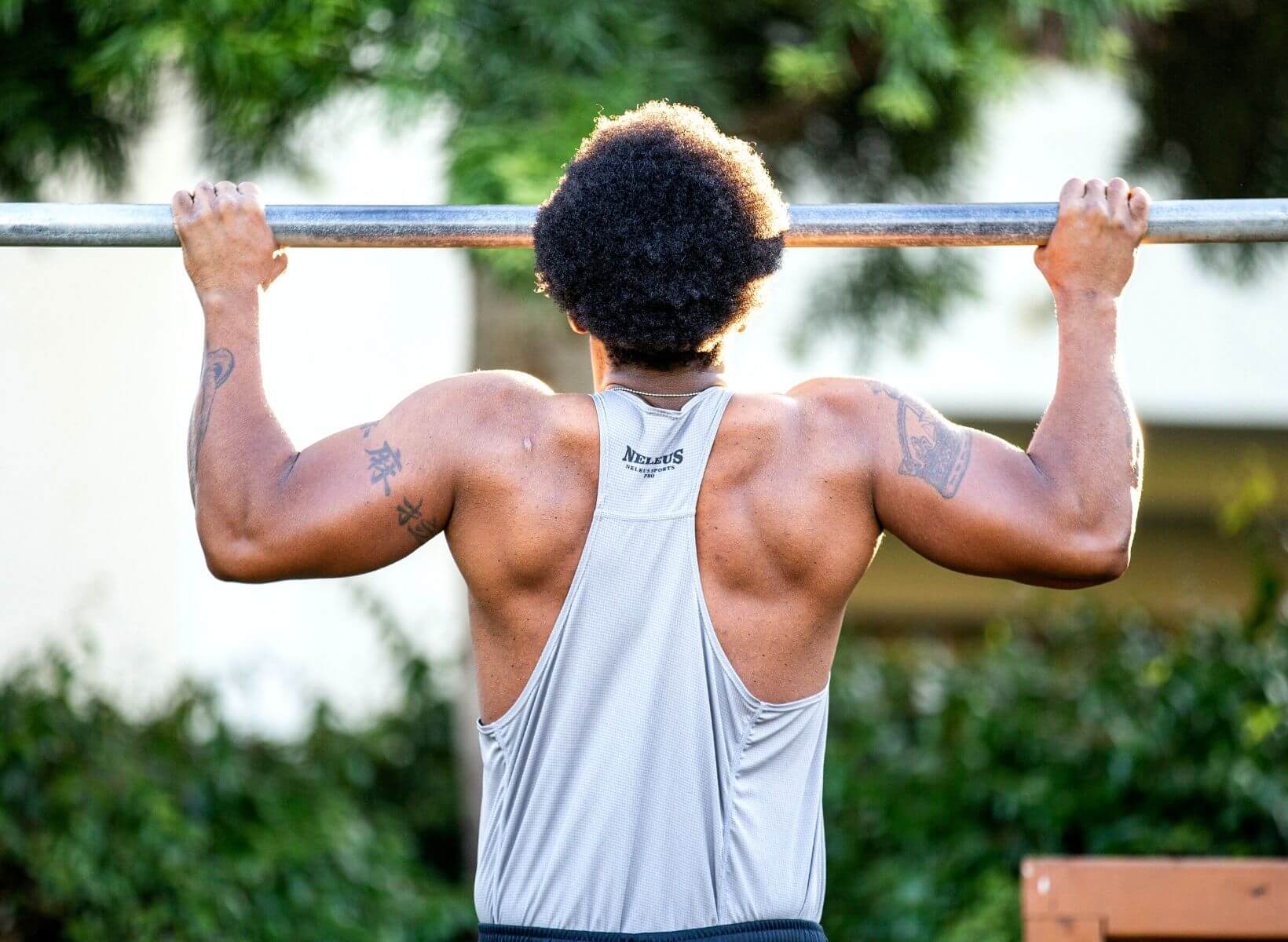 Man doing a pull up outside, an exercise that can burn glucose