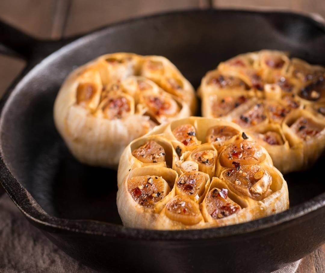 roasted garlic in a cast iron skillet