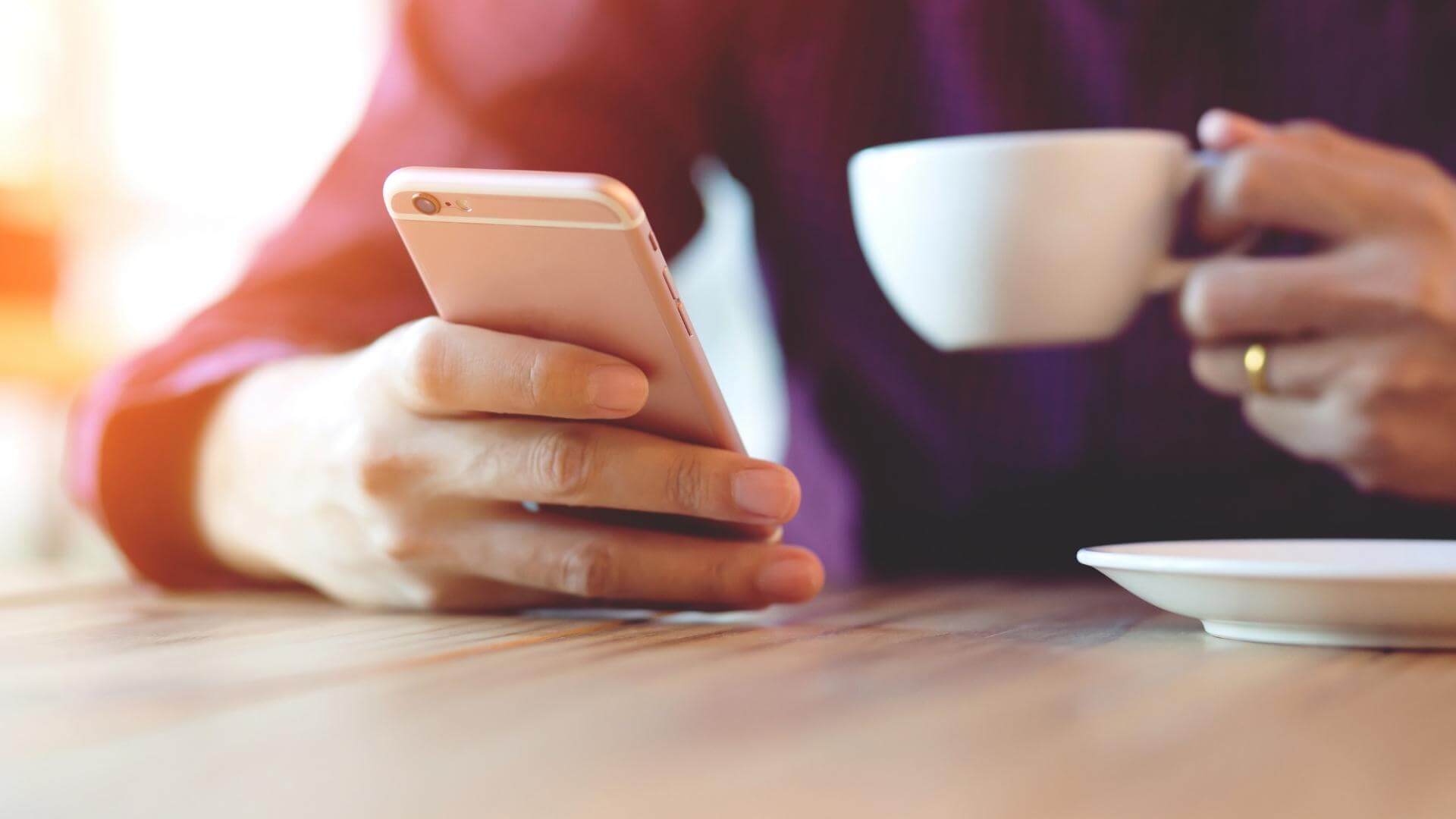 Person drinking coffee while looking at phone.