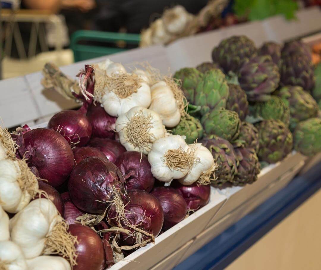 prebiotic-rich red onions, garlic and artichokes in a grocery store