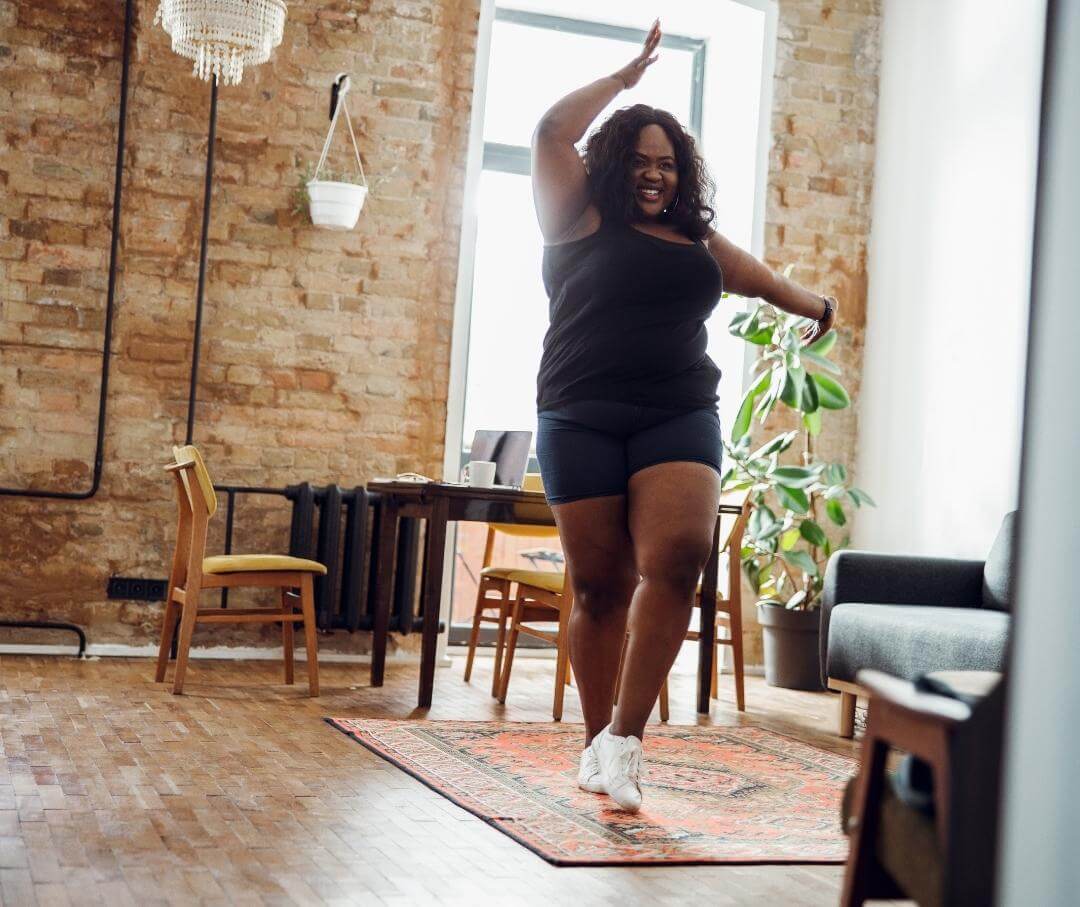 a heavyset woman happily dancing in her living room