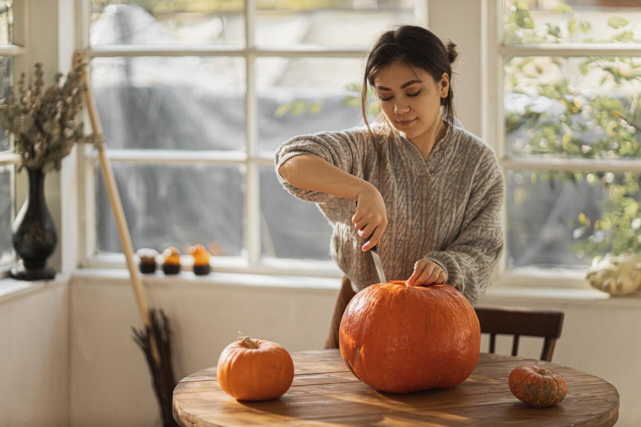 woman-carving-pumpkin-in-woodshed-at-her-house