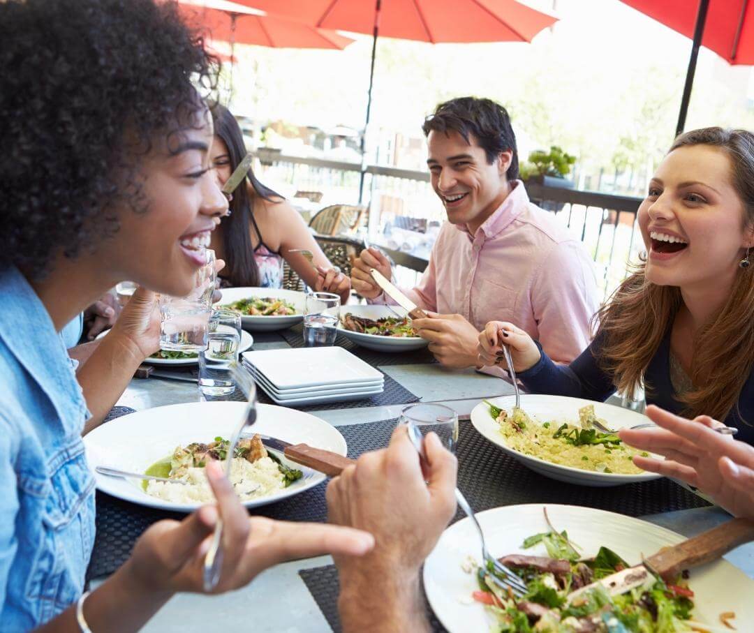 diverse group of friends eating lunch at an outdoor cafe