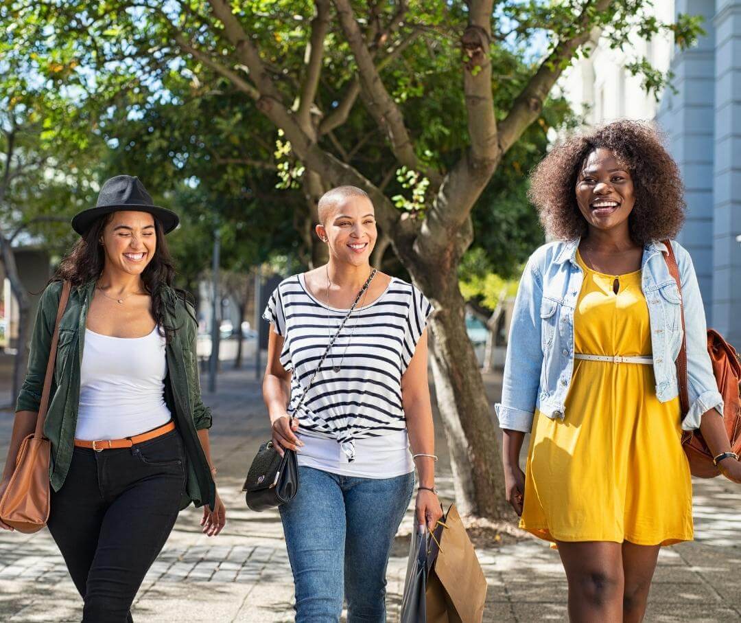 three women walking down the street in summer