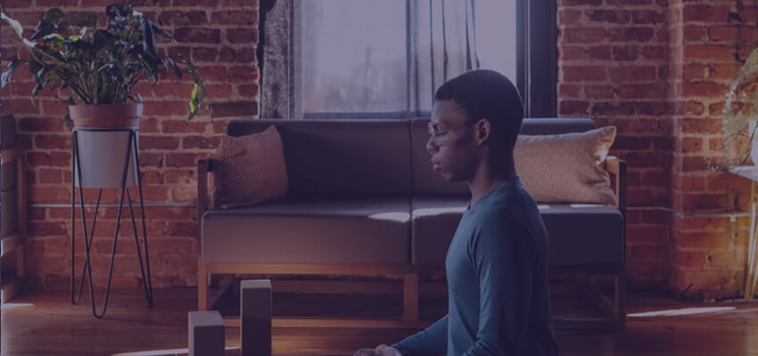 Man meditating in living room