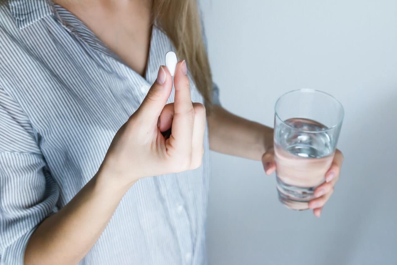 woman-taking-a-pill-with-water