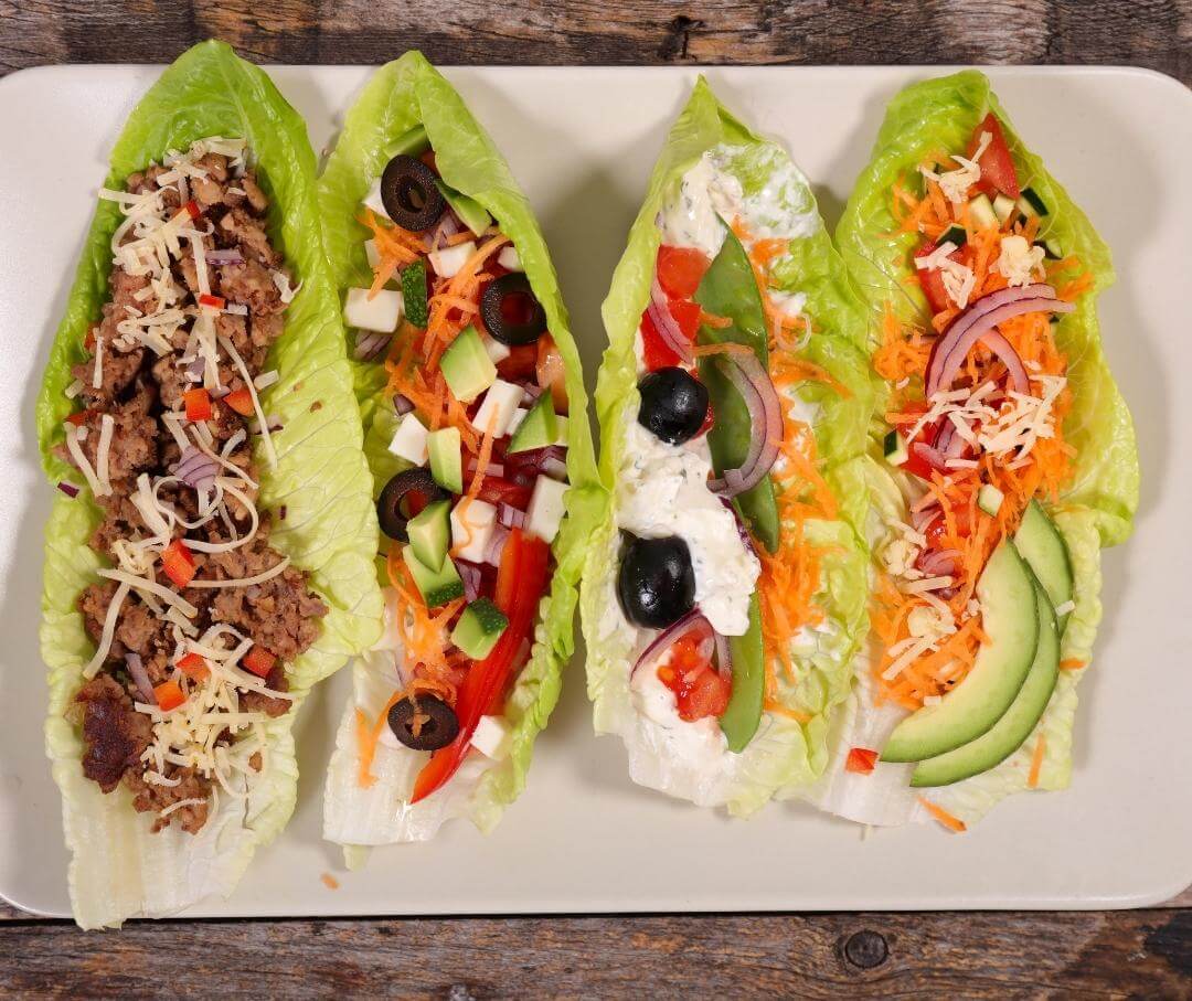 four lettuce wraps with different ingredients inside