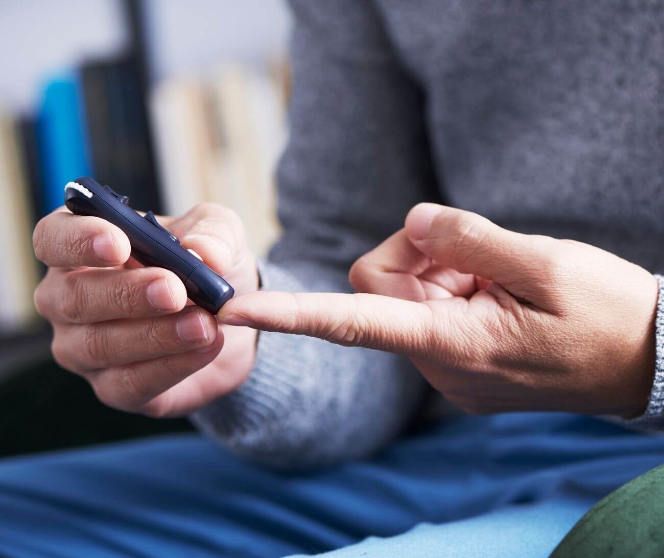 Man taking blood glucose reading with a fingerstick glucometer