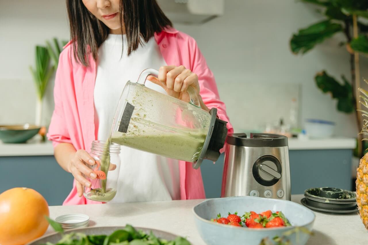 woman-pouring-green-juice-in-mazon-jar