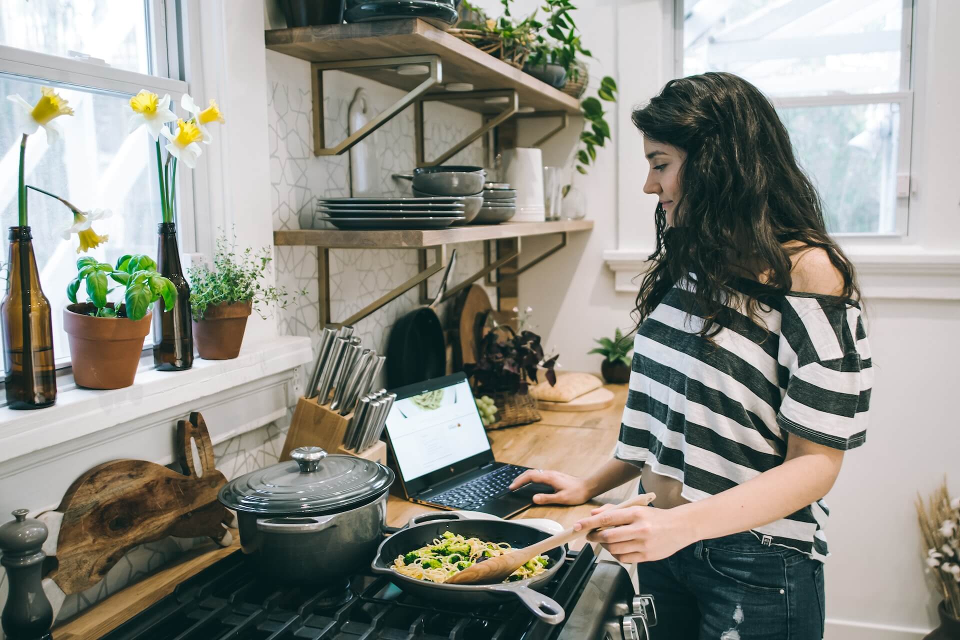 woman cooking a healthy meal while reading a tutorial