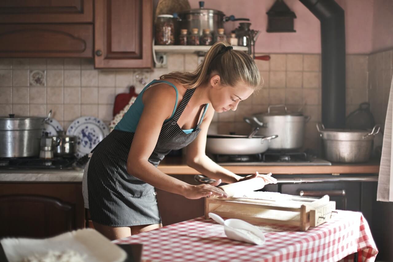 Young woman wolling dough for pasta