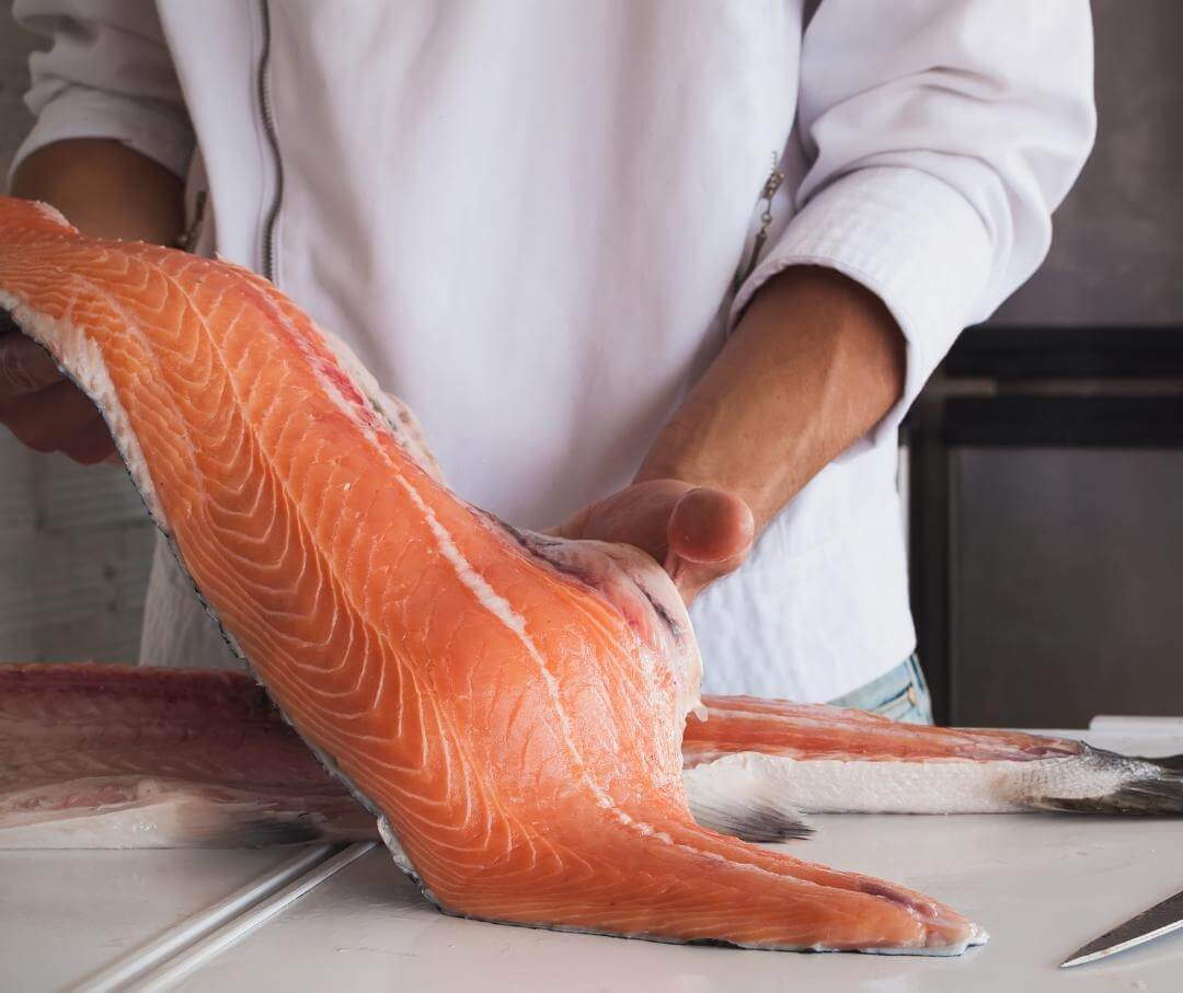 a chef holding a large salmon fillet