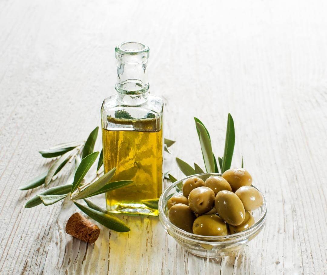 bottle of olive oil and a dish of green olives