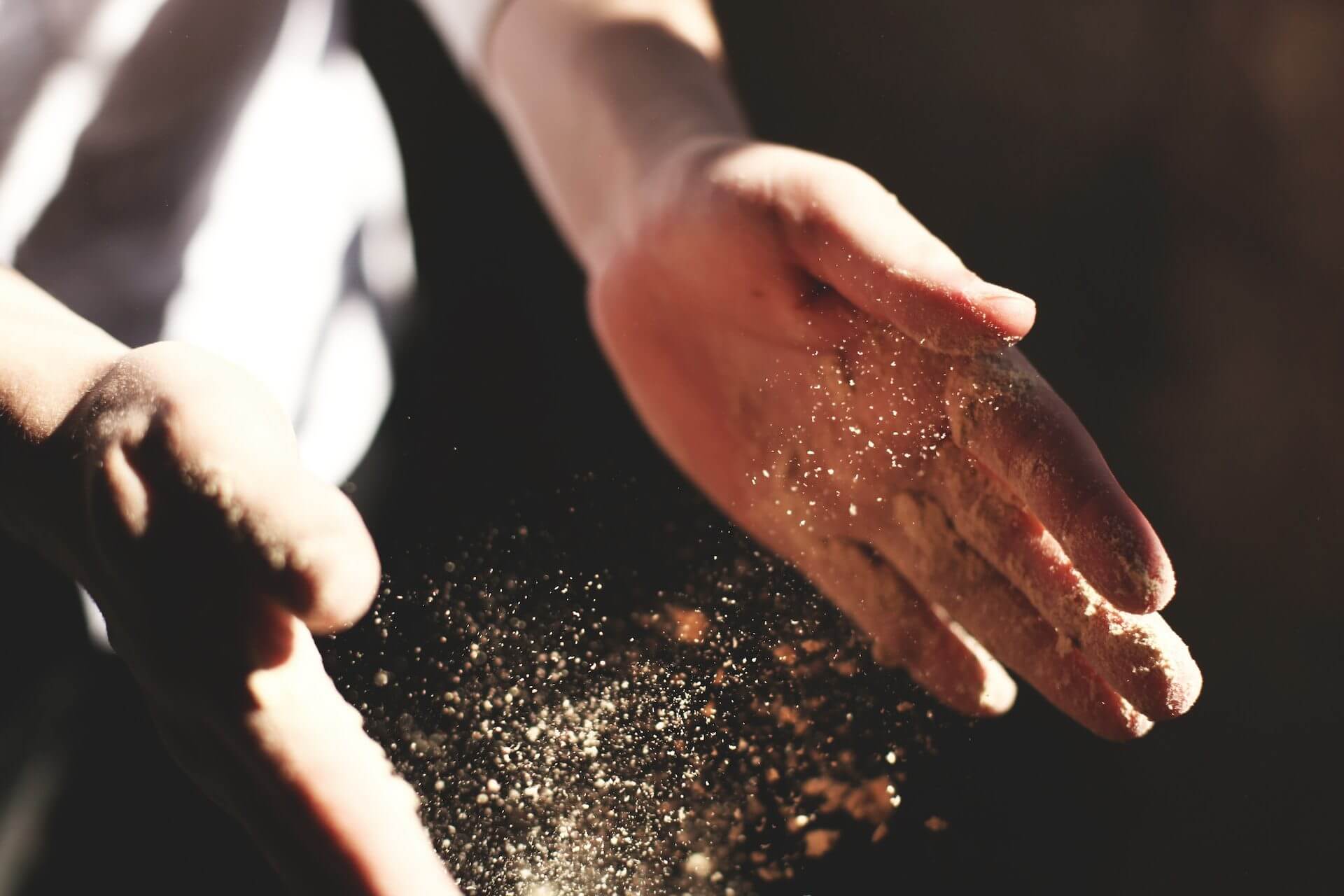 Close-up-of-hands-sprinkling-nutritional-yeast