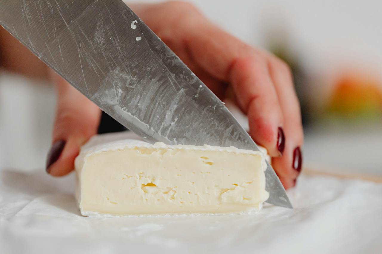 hands-of-a-woman-slicing-white-cheese