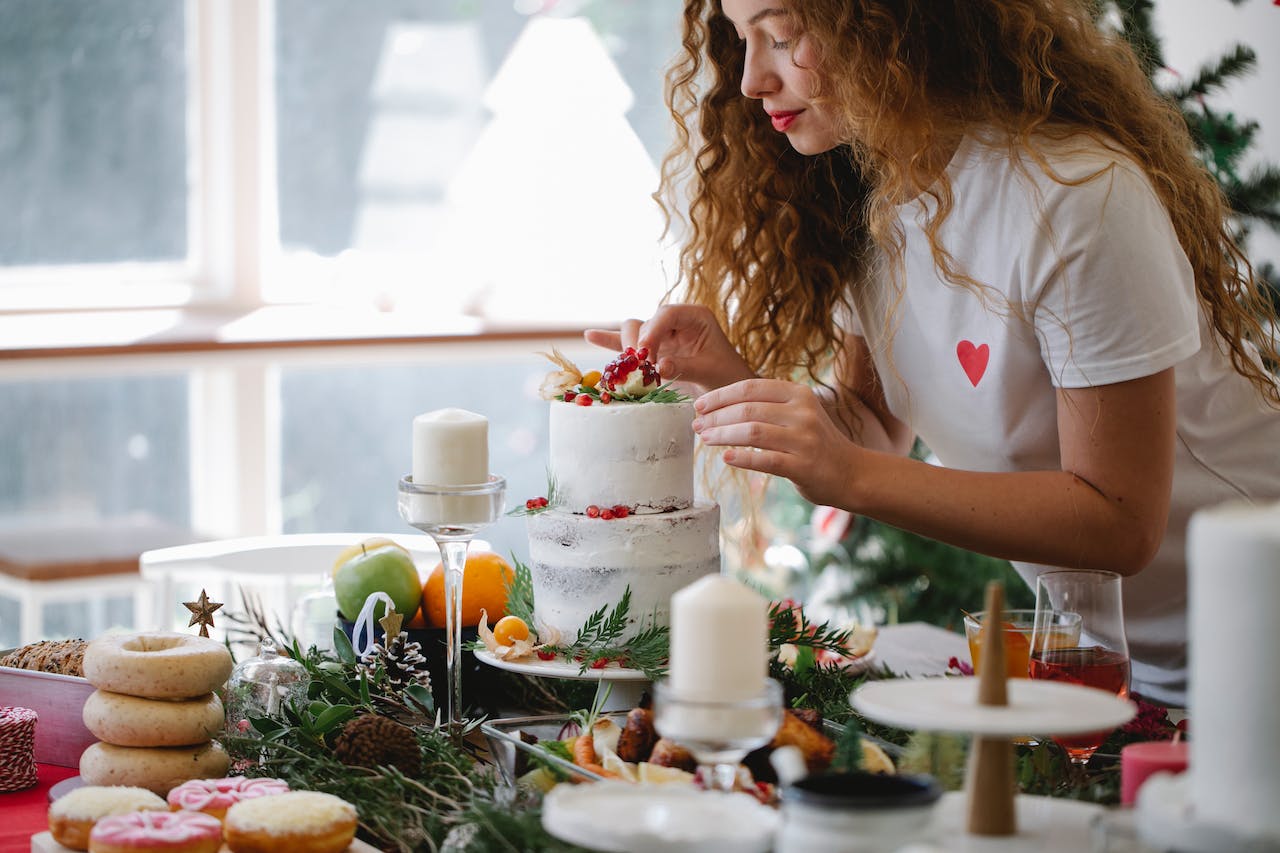 woman-decorating-cake-with-berries-for-christmas-celebration